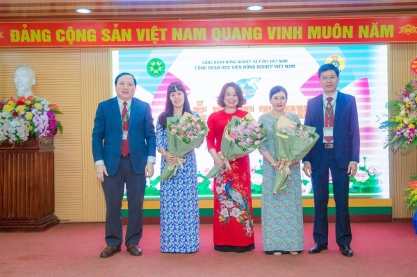TS. Vũ Ngọc Huyên và TS. Nguyễn Tất Thắng gửi tặng những bó hoa tươi thắm tới đại diện khách mời và cán bộ, viên chức nữ trong Học viện