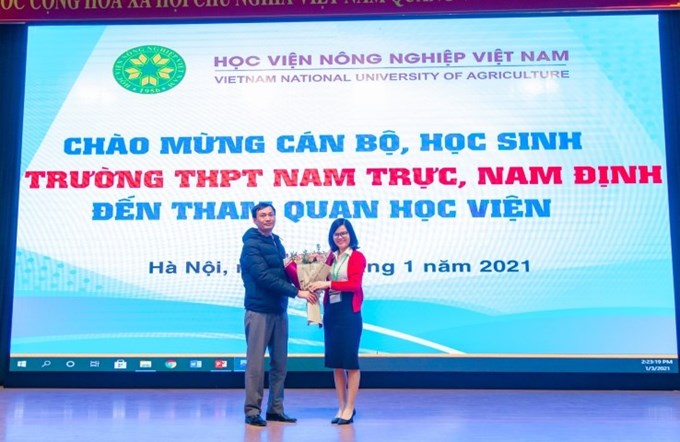 ThS. Đỗ Thị Kim Hương - Phó Giám đốc Trung tâm Quan hệ công chúng và Hỗ trợ sinh viên tặng hoa đại diện Trường THPT Nam Trực, Nam Định