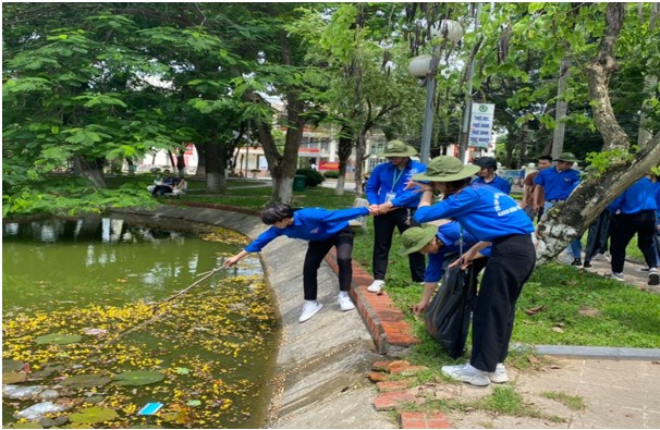 Sinh viên khoa Tài nguyên và Môi trường làm sạch môi trường tại khu vực Hồ Tình Bạn, trong khuôn viên xanh của Học viện