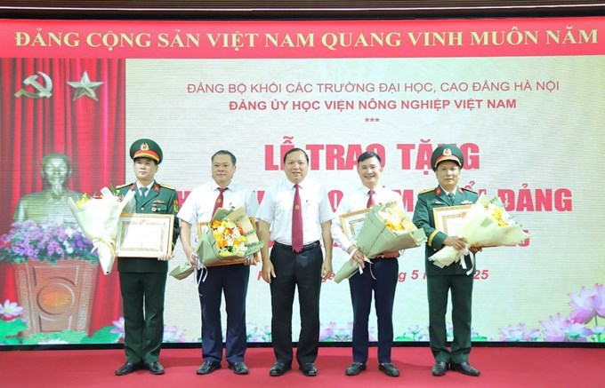 Đồng chí Vũ Ngọc Huyên - Phó Bí thư Thường trực Đảng uỷ, Phó Chủ tịch phụ trách Hội đồng Học viện, Phó Giám đốc Học viện trang trọng gắn Huy hiệu Đảng và tặng hoa chúc mừng cho các đồng chí vinh dự nhận Huy hiệu 30 năm tuổi Đảng