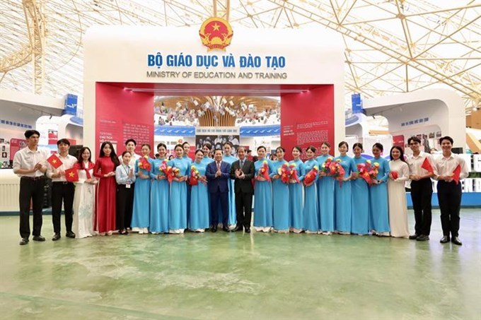 Bộ trưởng Nguyễn Kim Sơn, Thứ trưởng Lê Tấn Dũng chụp ảnh lưu niệm cùng các em sinh viên tại khu trưng bày của Bộ Giáo dục và Đào tạo tại Trung tâm triển lãm quốc gia(Ảnh sưu tầm)