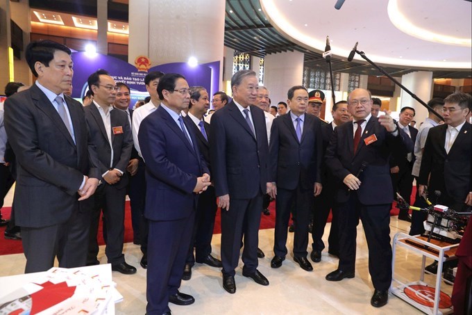 Tổng Bí thư Tô Lâm, Chủ tịch nước Lương Cường, Thủ tướng Chính phủ Phạm Minh Chính, Chủ tịch Quốc hội Trần Thanh Mẫn và các đại biểu nghe giới thiệu các thành tựu, sản phẩm tiêu biểu tại Triển lãm. Ảnh: Hồ Long